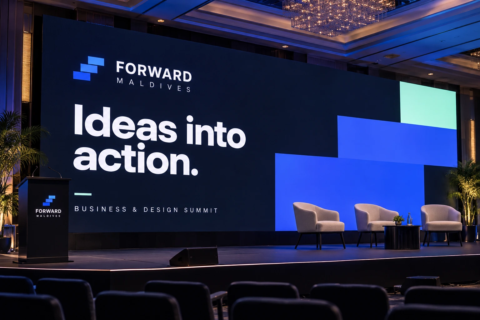The Forward Maldives stage screen reads “Ideas into action.” in white on navy, with blue and mint blocks behind three armchairs and a branded lectern.